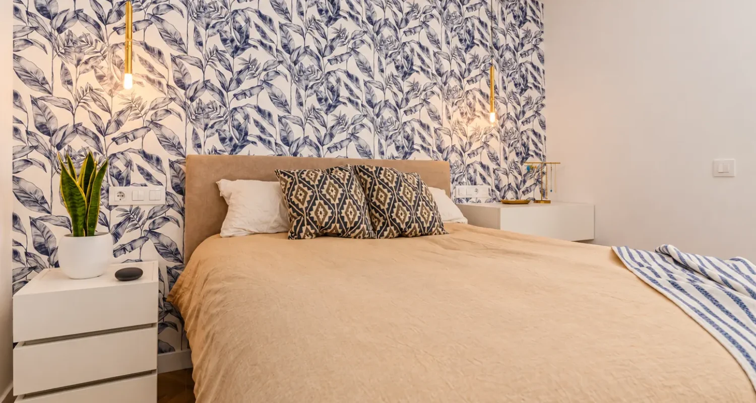 Dormitorio principal con cabecero de papel pintado azul en reforma integral Madrid por Global Oltenia