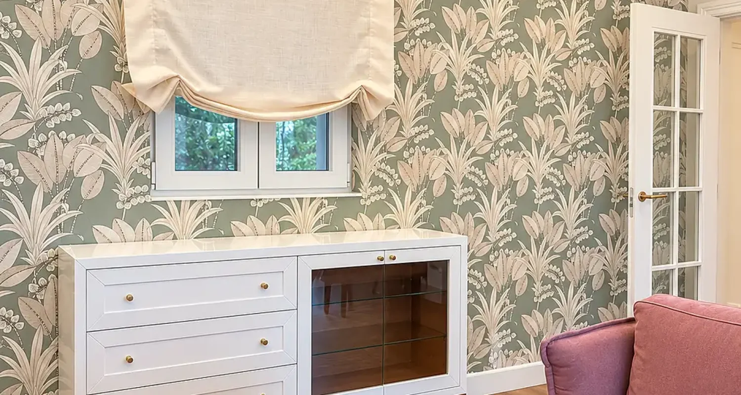 Salón de reforma integral de piso en Alonso Cano, Madrid, con aparador blanco, papel pintado floral e iluminación indirecta.