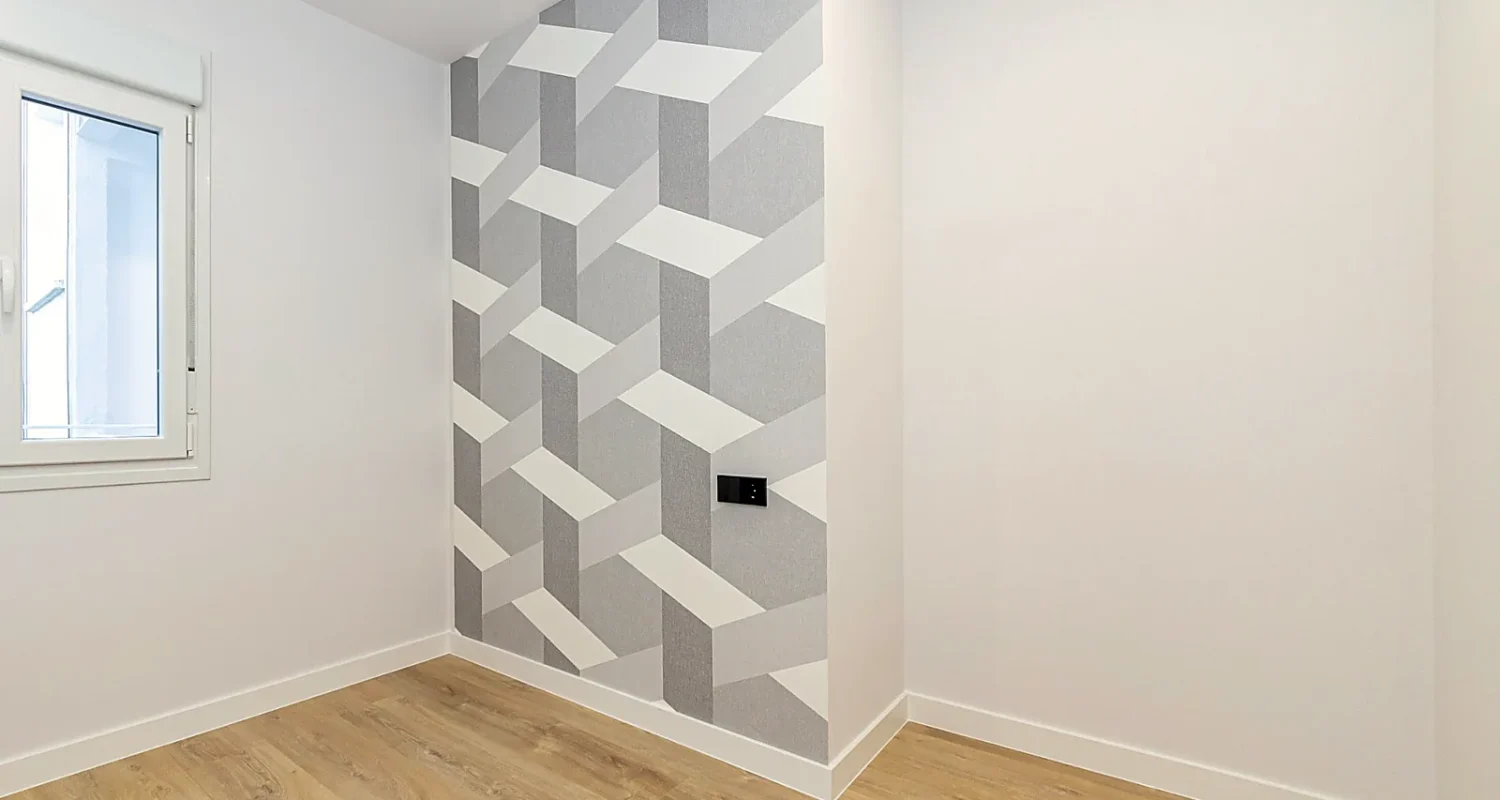 Dormitorio reformado en Calle Tarragona, Madrid, con papel pintado geométrico en tonos grises y blancos