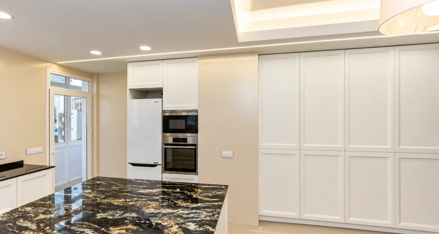Cocina moderna con isla y encimera de piedra en reforma integral calle Galileo Madrid