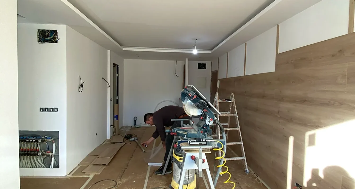 Trabajos de carpintería y colocación de revestimiento de madera en el salón de una reforma integral en Mejorada del Campo, Madrid.