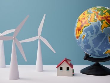 windmill and house models with big globe on white table and blue background windmill and house models with big globe on white table and blue background